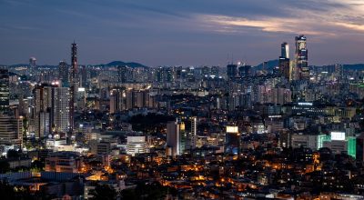 风筝电视剧剧照，主角身着长风衣站在城市夜景前，神情复杂而坚定